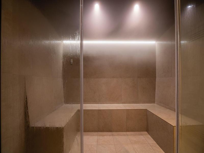 Sala de vapor moderna con acabado de madera e iluminación suave para relajación en el hotel.