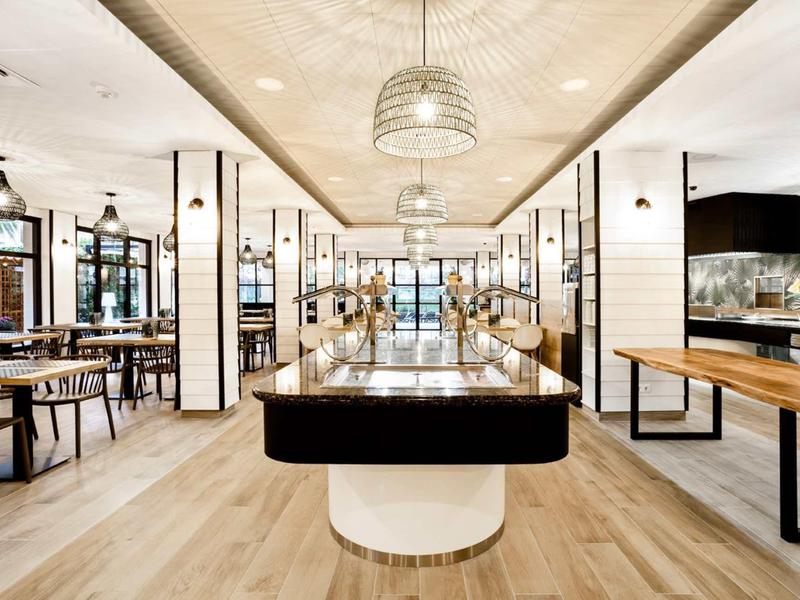 Spacious, brightly lit dining area with wooden floors and modern lighting.