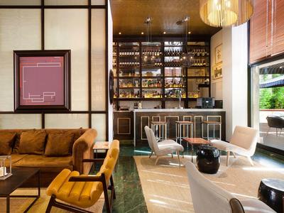 Moderner Wohn- und Essbereich mit braunem Sofa, Barhockern, großem Fenster und stilvoller Beleuchtung.