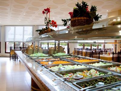 Buffet avec une variété de plats dans un restaurant lumineux avec de grandes fenêtres.