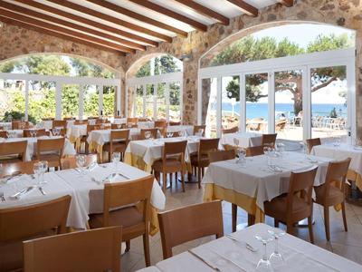 Open restaurant met houten balkenplafond en uitzicht op zee bij daglicht.