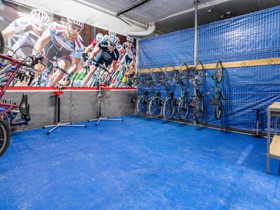 Fahrradabstellraum mit mehreren Fahrrädern und bemalter Wand im Hintergrund.