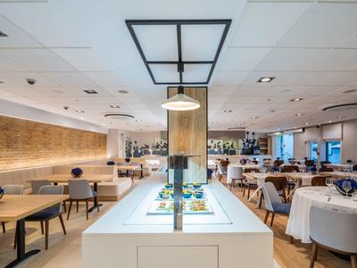 Moderní jídelna s prostřenými stoly a světlým osvětlením.