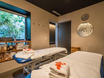 Spa místnost se dvěma masážními lehátky, ručníky a útulnou výzdobou.