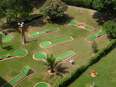 Percorso di mini golf con varie buche in un giardino curato
