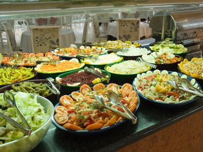 Buffet vario con insalate, frutti di mare e verdure fresche al bancone di un hotel.
