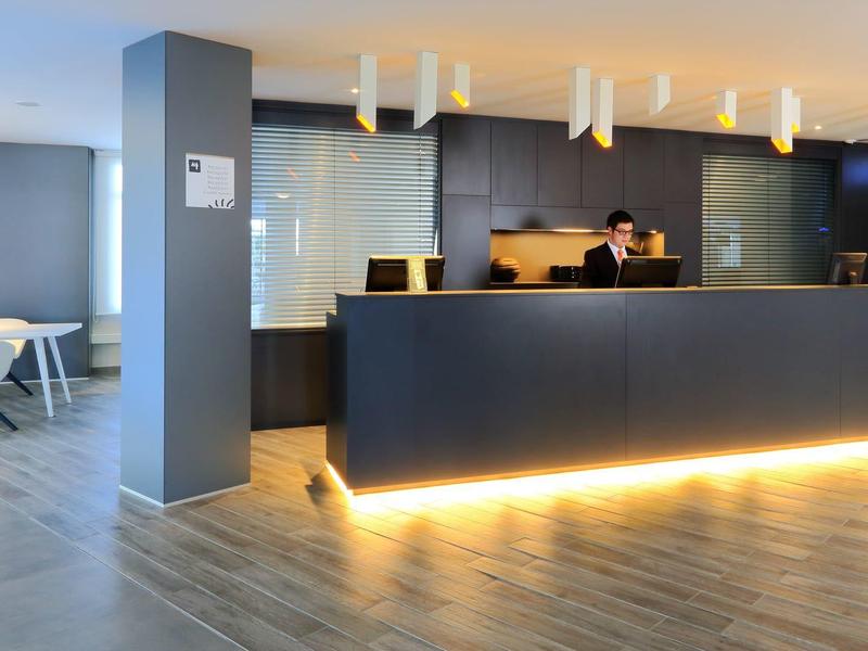 Modern hotel reception area with sleek black desk and warm under-lighting