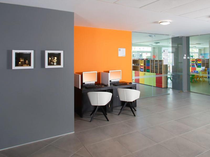 Modern hotel lobby with seating, colorful walls, and large glass windows.