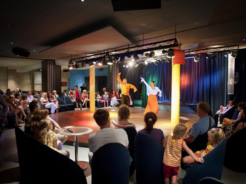 Escenario con dos bailarines y público en una sala de eventos del hotel.