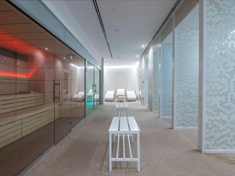 Área de spa moderna con sauna y tumbonas, diseño limpio y minimalista.
