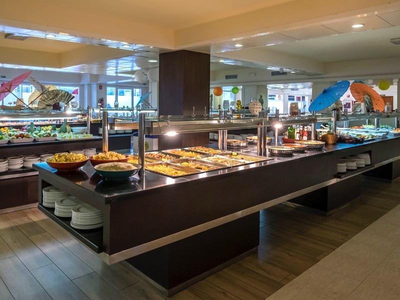 Duży bufet z różnorodnymi potrawami w nowoczesnej restauracji hotelowej.