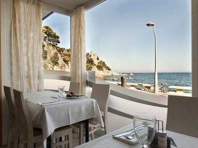 Restaurant lumineux avec vue sur la côte et la mer par temps clair.