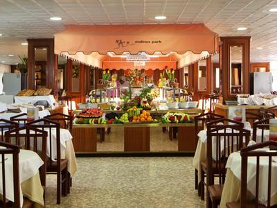 Large dining room with buffet and set tables in a hotel.