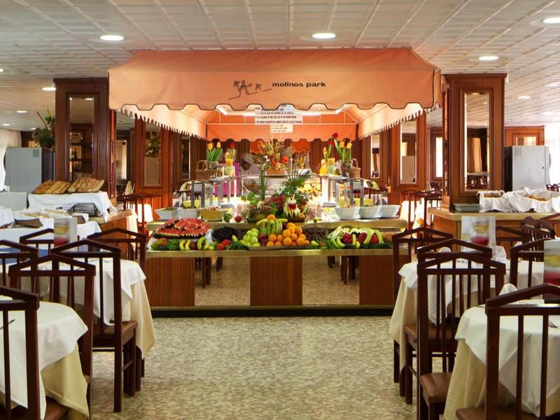Large dining room with buffet and set tables in a hotel.
