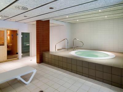 Hôtel moderne avec terrasses et palmiers sous un ciel bleu ensoleillé.