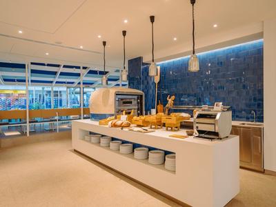 Buffet moderne avec pain, grille-pain et éclairage dans une salle à manger lumineuse et élégante.