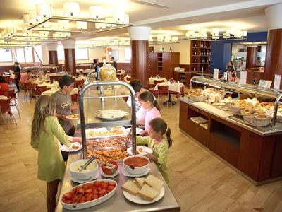 Buffet dans une salle spacieuse avec familles et une variété de plats.
