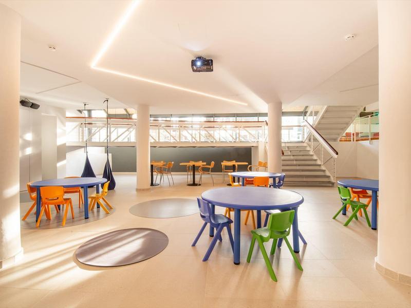 Salon lumineux et moderne avec mobilier coloré pour enfants et grande fenêtre