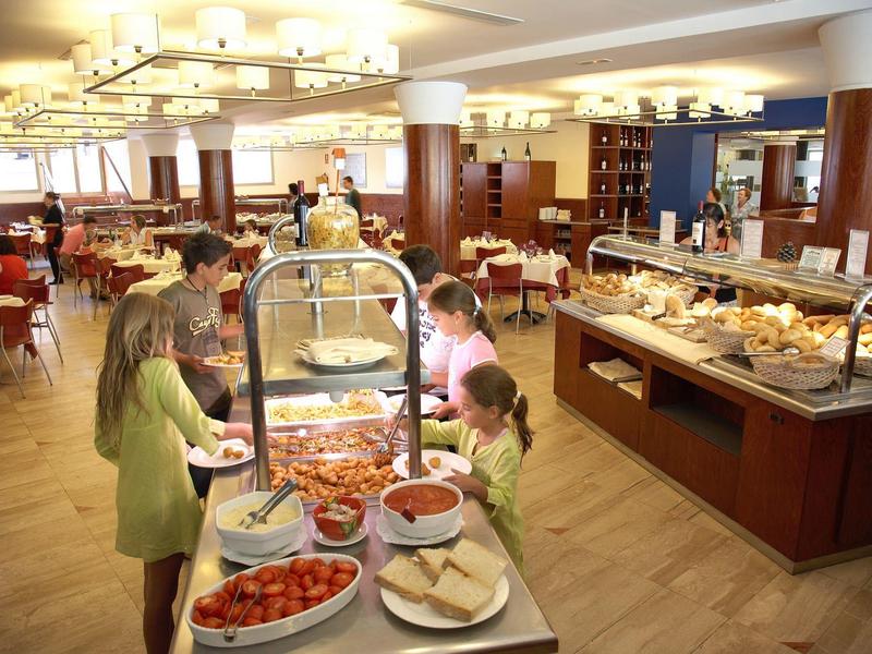 Buffet dans une salle spacieuse avec familles et une variété de plats.