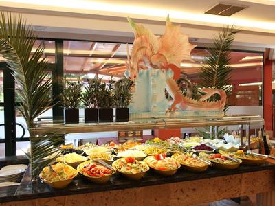 Buffet table with various salads and condiments, decorated with a large seafood sculpture