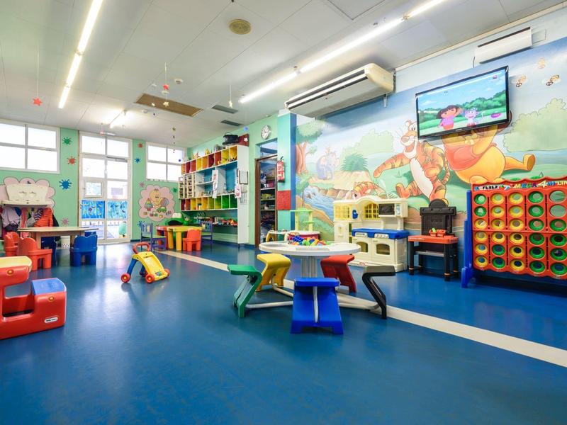 Sala de juegos colorida para niños con muebles y murales en un hotel o lugar de vacaciones.