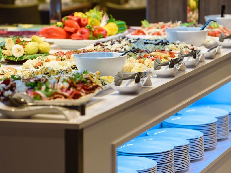 Buffet con variedad de platos frescos y vajilla en el restaurante del hotel.