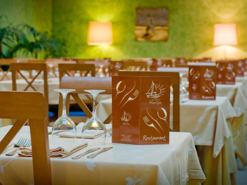 Un ristorante con tovaglie bianche, mobili in legno e illuminazione soffusa.