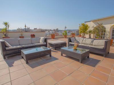 Amplia terraza en la azotea con muebles modernos y plantas, lugar perfecto para relajarse.