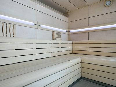 Lichte, moderne sauna met horizontale houten banken en indirecte verlichting.