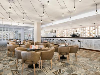 Moderne hotelbar met comfortabele stoelen en verlichte toonbank.