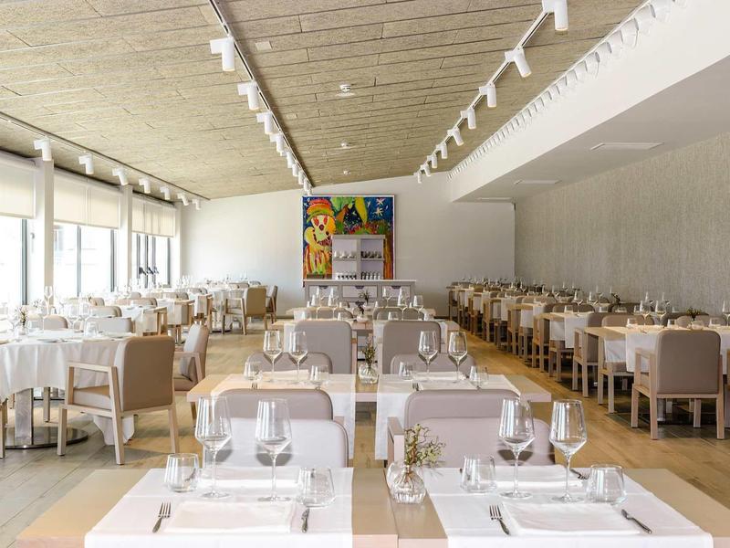 Bright restaurant with white-set tables and modern decor.