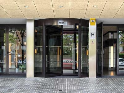 Eingangsbereich mit automatischen Glasschiebetüren, Marmorwänden und Deckenleuchten.