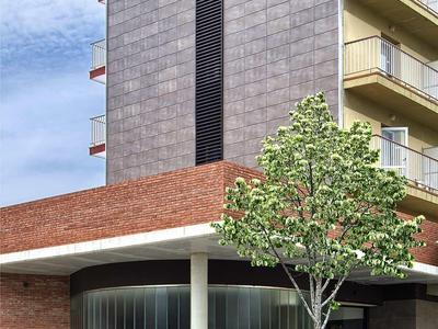 Modernes Hotelgebäude mit dunklen Fassaden, Balkonreihen und Baum vor Glasfront und Eingang.