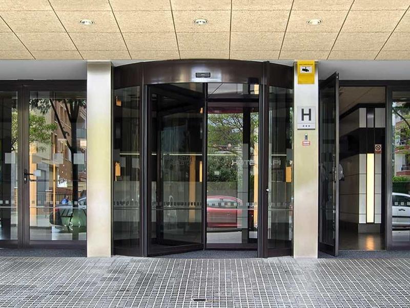 Eingangsbereich mit automatischen Glasschiebetüren, Marmorwänden und Deckenleuchten.