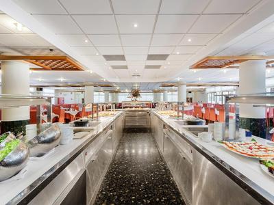 Velká hotelová bufetová oblast s různými pokrmy a moderními světlými stropy.