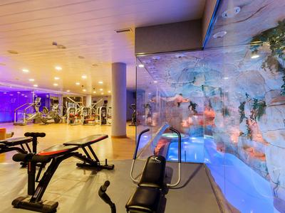 Salle de sport moderne avec équipements et décoration murale aquatique dans un hôtel