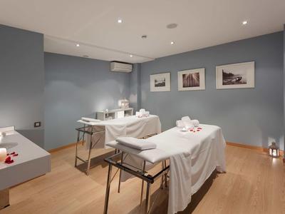 Pokoj pro masáže s dvěma lehátky a jemným osvětlením.