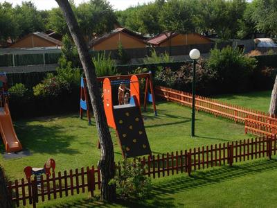 Dětské hřiště s klouzačkou, lezeckou stěnou a dřevěným plotem na zahradě.