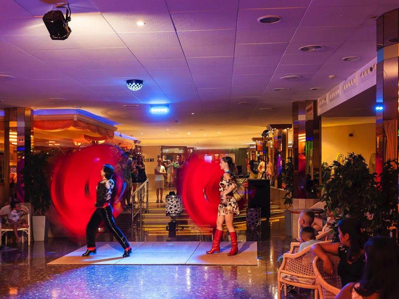 Dva tanečníci vystupují v elegantní hotelové restauraci před publikem.