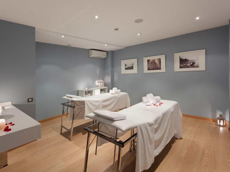 Pokoj pro masáže s dvěma lehátky a jemným osvětlením.