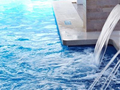 Piscina con chorros de agua estrechos en una piscina de hotel durante el día