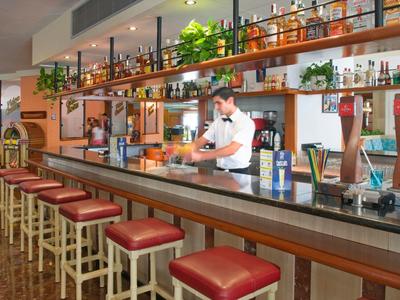 Bar moderna con taburetes rojos y camarero en un hotel