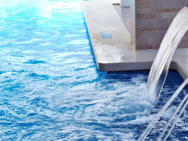 Piscina con chorros de agua estrechos en una piscina de hotel durante el día