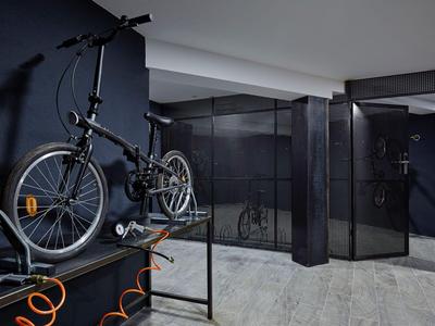 Moderne Fahrradwandhalterung in einem stilvollen, dunklen Hotelkeller oder Abstellraum.