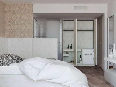 Modern bedroom with white bed, wall-mounted TV, and minimalist decor