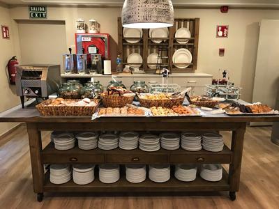 Buffet with baked goods and plates in a hotel restaurant.