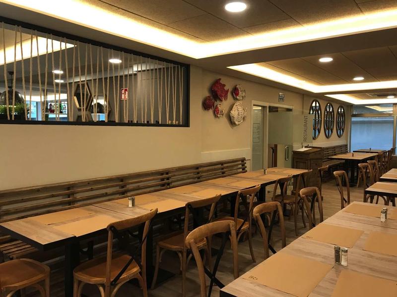 Empty dining area with wooden tables and chairs in a modern restaurant.