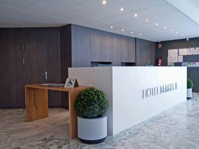 Nowoczesna recepcja hotelowa z białym kontuarem i drewnianą ławką.