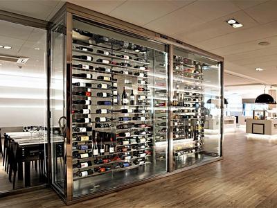 Nowoczesny pokój na wino ze szklanymi ścianami w stylowej restauracji hotelowej z drewnianą podłogą.