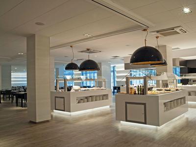 Nowoczesna restauracja hotelowa z stylowym oświetleniem i eleganckimi bufetami.